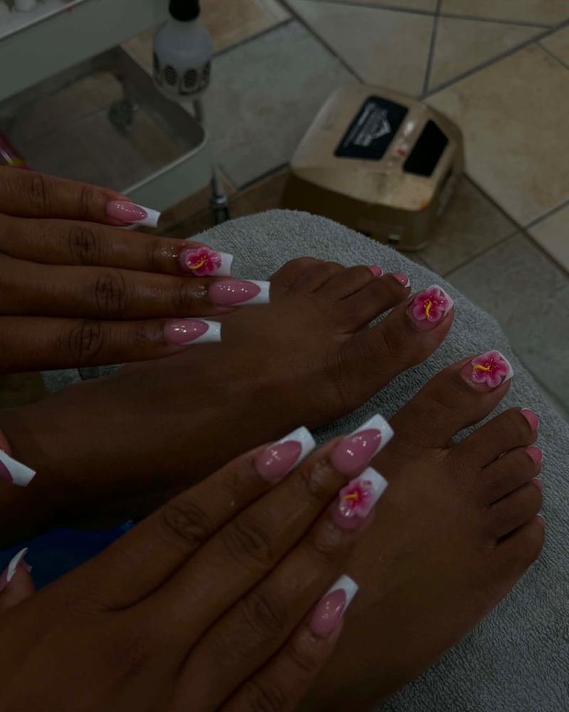 A signature pedicure with French tips and hand-sculpted pink flowers, made at Top Nails